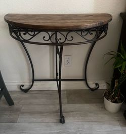 Half Moon Console Table  Beautiful half-moon console table with a solid wood top and decorative metal base. Great for an entryway, hallway, living roo