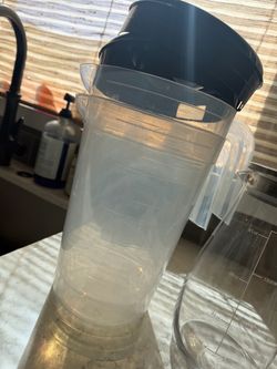 2 Clear Plastic Pitcher with Black lid and Glass pitcher with metal lid