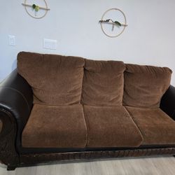 Large Brown Couch with Carved Wooden Accent Design