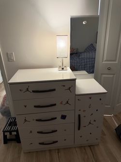 Eso es una cómoda infantil con cajones y armario lateral, también llamada dresser infantil / chest of drawers with wardrobe.