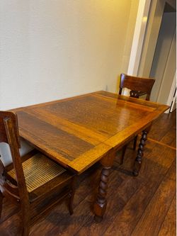 Solid oak pub/game table and 4 matching cane-seat chairs.