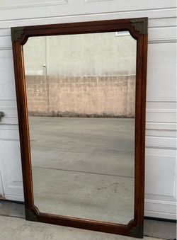 Vintage wooden frame mirror with metal corner accents. 27 1/4” X  43”