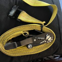 Heavy-duty yellow ratchet strap for securing loads.