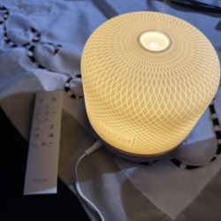 This is a NEOM Wellbeing Pod Essential Oil Diffuser with a white ceramic cover.