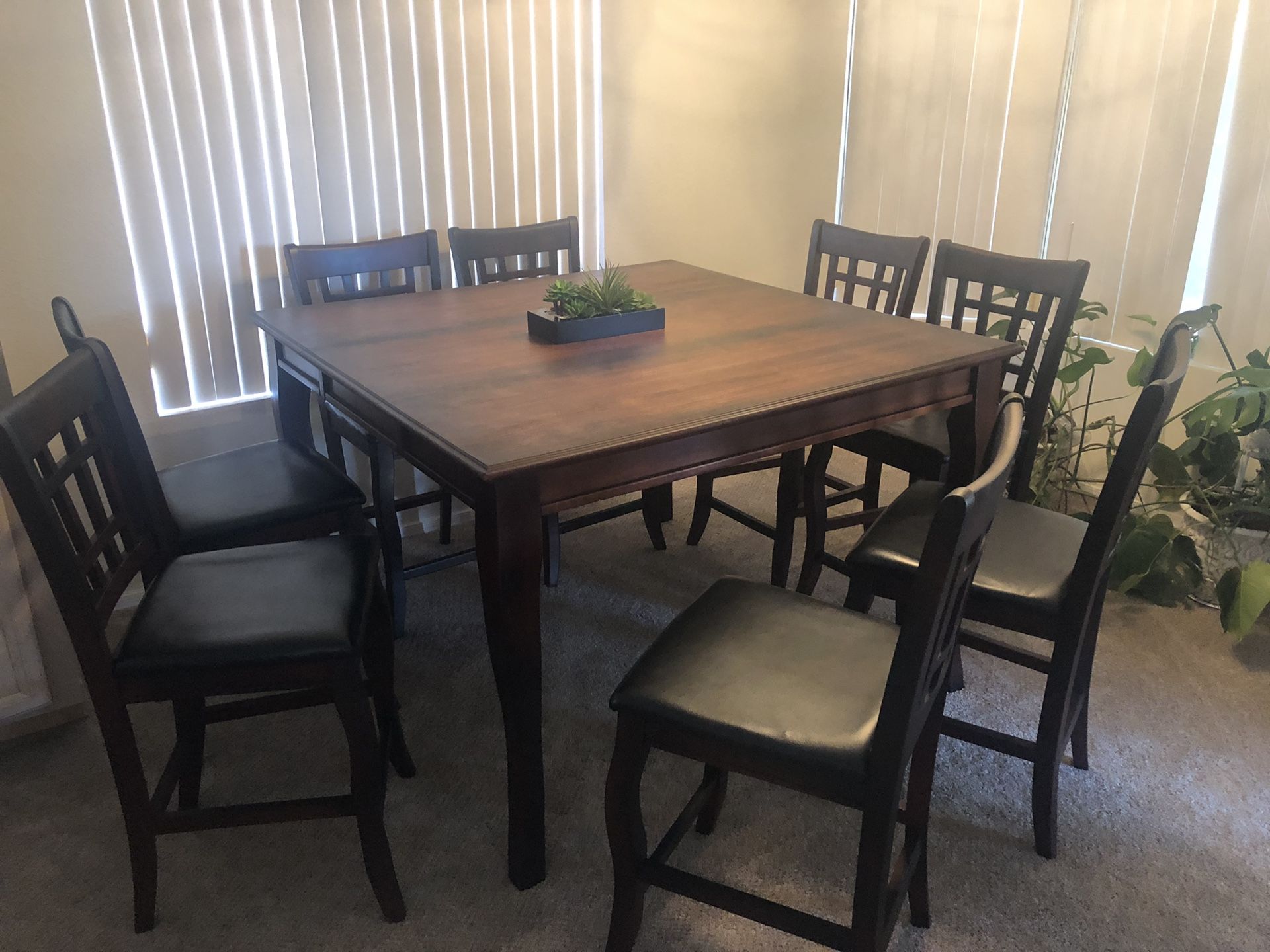 Pub height dining table and 8 leather padded chairs. Delivery available