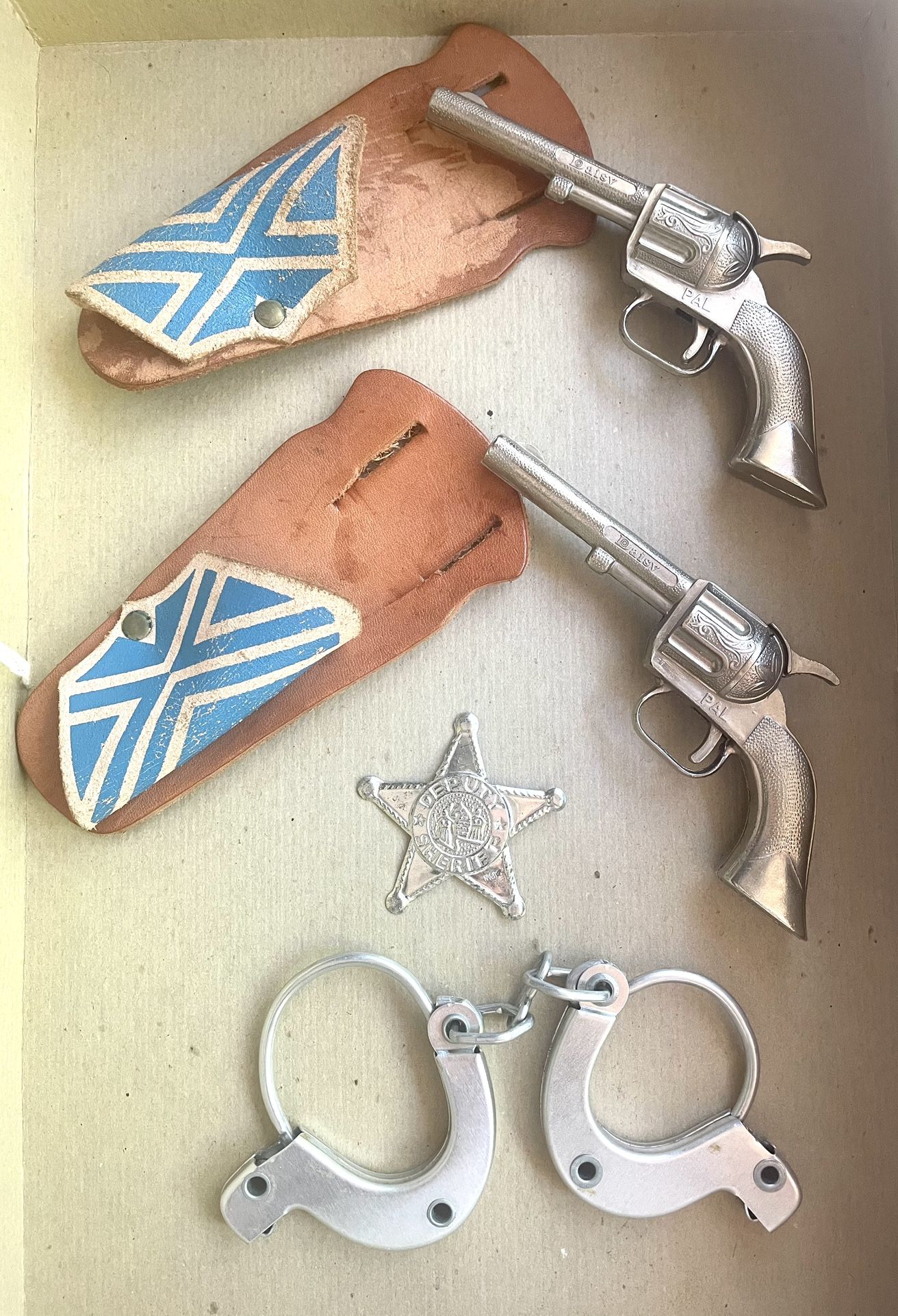 Pair of Vintage 6” Daisy Pal Toy Guns with Original Holsters, Toy Badge, and Toy Handcuffs
