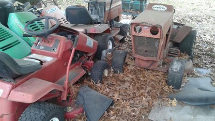 Three old riding lawn mowers