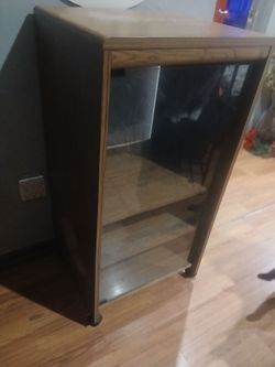 Solid wood cabinet has glass door