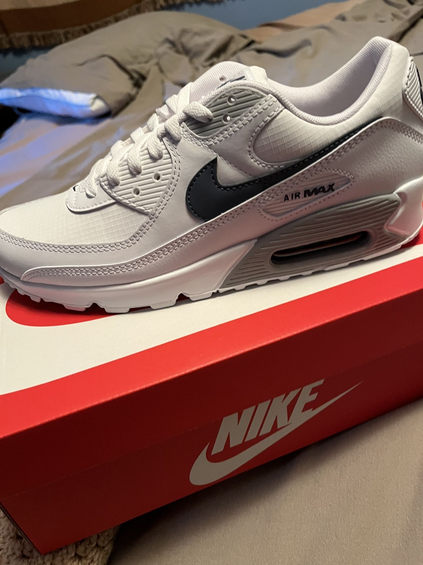 Nike Air Max 90 All White With A Silvery Blue Swoosh.