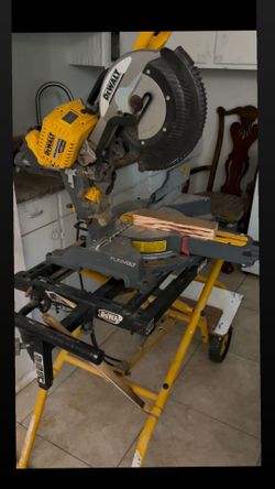 Powerful DEWALT FLEXVOLT 120V MAX brushless miter saw is mounted on a yellow and black DEWALT rolling miter saw stand. The tool has a grey and yellow 