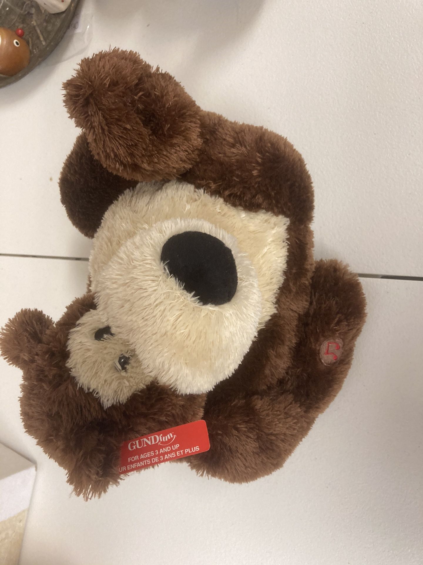 Retired Gund bear that sings”be happy.”