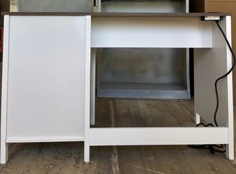 New White and Wood Grain Desk with Built-in Power Outletsr It comes packaged; there is a small dent