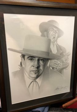 Jimi Hendrix and Stevie Ray Vaughan framed charcoal drawings.