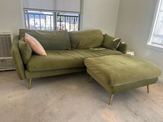 Green velvet sofa with resting feet table