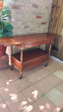 Antique table that can be made smaller on both sides.