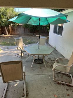 Patio table, chairs, and umbrella