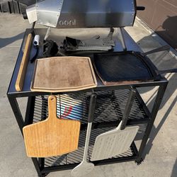 Ooni pizza oven with tons of accessories and table on wheels for sale