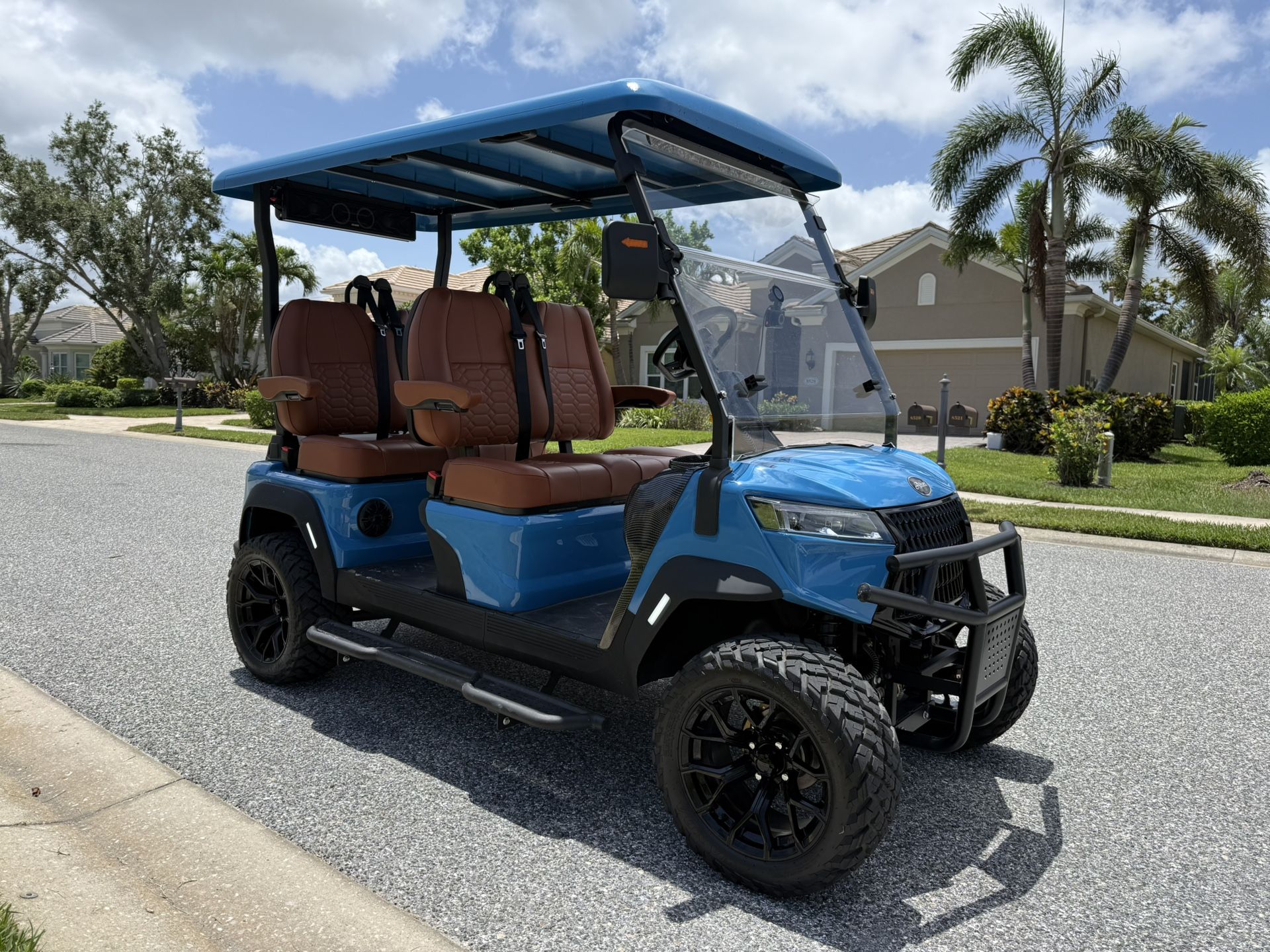 Fully loaded, lifted golf cart with four forward-facing seats.