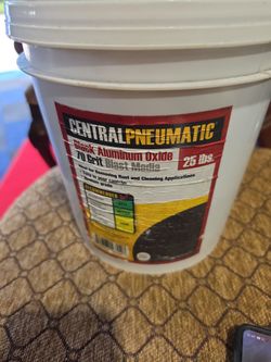 25-pound bucket of Central Pneumatic Black Aluminum Oxide 70 Grit Blast Media designed for removing rust and cleaning metal surfaces.