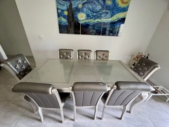 Modern dining table set with 6 chairs and glass top.
