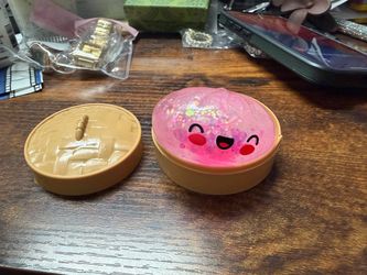 This pink sequined *xiaolongbao* (soup dumpling) stress-relief squeeze toy comes with its own miniature steamer basket and features a playful design w