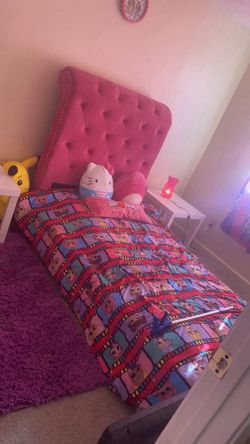 Pink tufted twin size bed with mattress