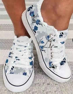white low-top sneakers featuring a blue floral toile pattern
