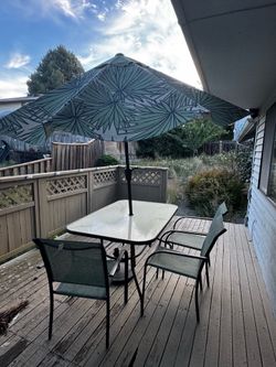 A set of patio table and 6 chairs and an umbrella