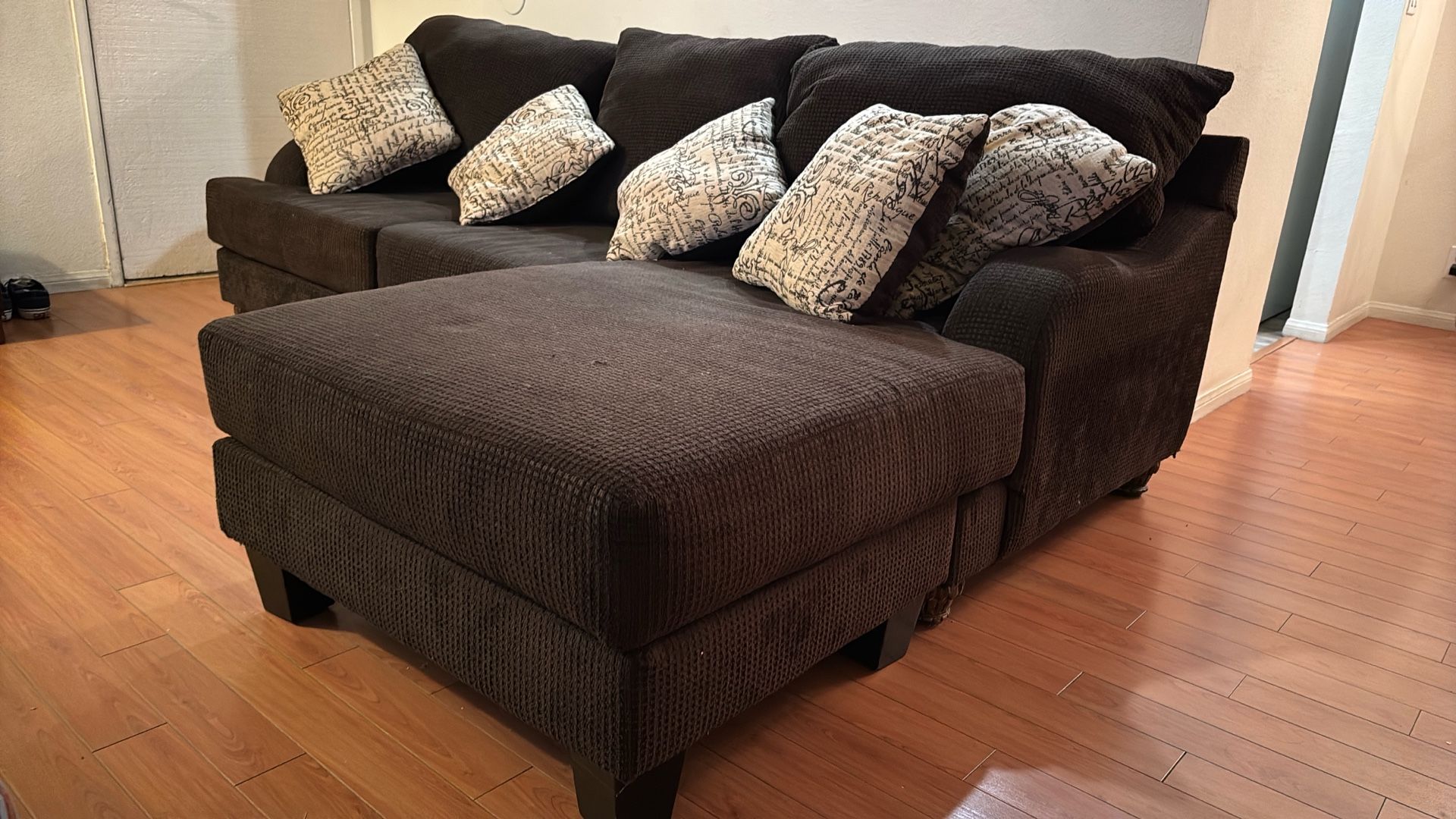 Brown couch with detachable extension and pillows
