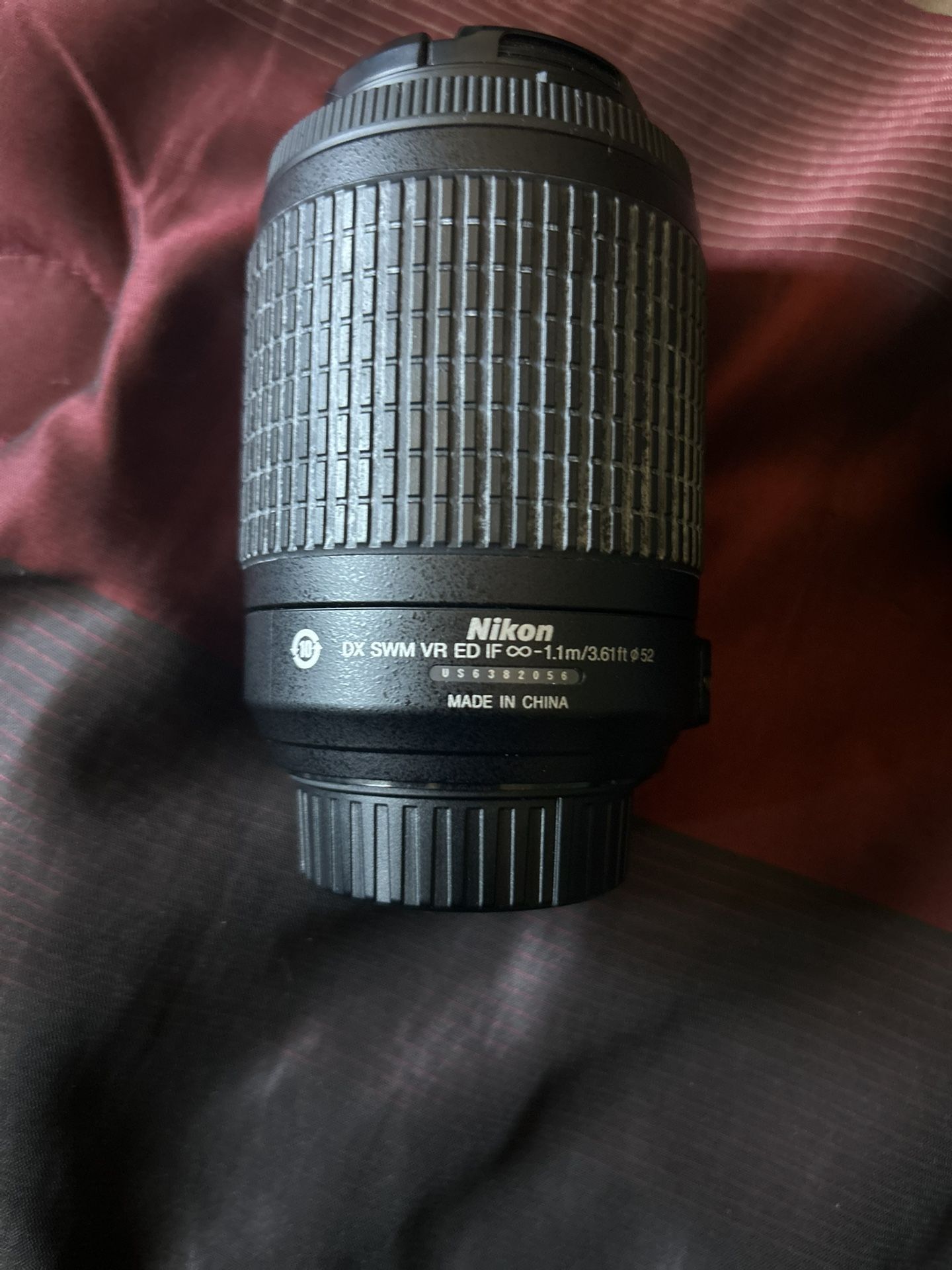 Nikon AF-S DX Zoom-NIKKOR 55-200mm f/4-5.6G ED lens and Nikon MH-24 battery charger, and a packaged Nikon EN-EL14 battery