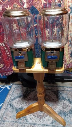 Pair of SSF coin-operated gumball/candy vending machines .with clear globe tops, gold lids green and gold base.