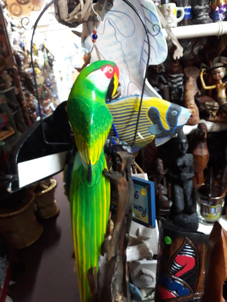 Cool large colorful carved wooden parrot on a swing