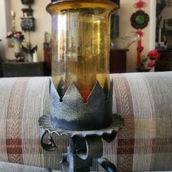 vintage wrought iron and amber glass table lamp featuring a decorative scrollwork design. 