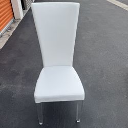 Modern white side chair is the Siena model by Chintaly Imports, featuring acrylic front legs and white PU upholstery