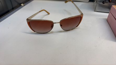 vintage-inspired butterfly or aviator sunglasses featuring a gold metal frame, brown gradient lenses, and distinctive orange enamel accents along the 