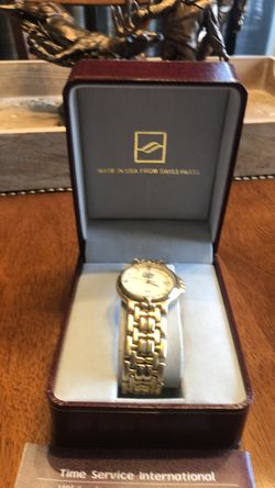 Men’s gold watch, has never been worn. Still in the box with extra links.