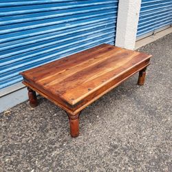 Solid wood thakat style coffee table with nailhead trim on top. Measures approx: 53" wide 