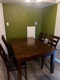 Dining table with 4 matching chairs and leaf extension included.