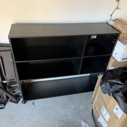 black modern shelving unit or TV stand with open compartments for storage