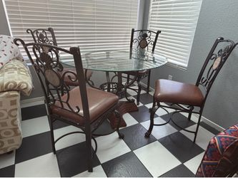 Glass table with metal framing wood base and 4 metal chairs