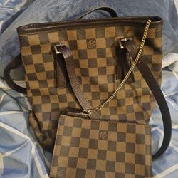 This is a pre-owned Louis Vuitton Damier Ebene Marais bucket bag, recognizable by its iconic brown checkered pattern. 