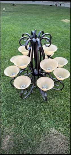12-light, oil-rubbed bronze chandelier featuring ornate scrollwork and frosted ivory glass shades