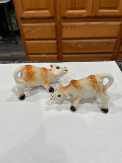 Vintage Ceramic cow pair of salt and pepper shakers. Size approximately 3 1/2 inches long and 2 inches tall. Preowned with cork stoppers. Some mino