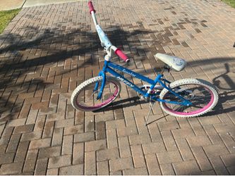 This is a Huffy Seastar children’s bike featuring a bright blue frame with pink accents on the rims, grips, pedals, and seat details, plus a white sea