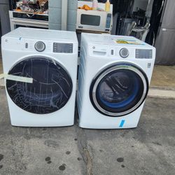A pair of washing machines are gas-powered and are new, GE brand.