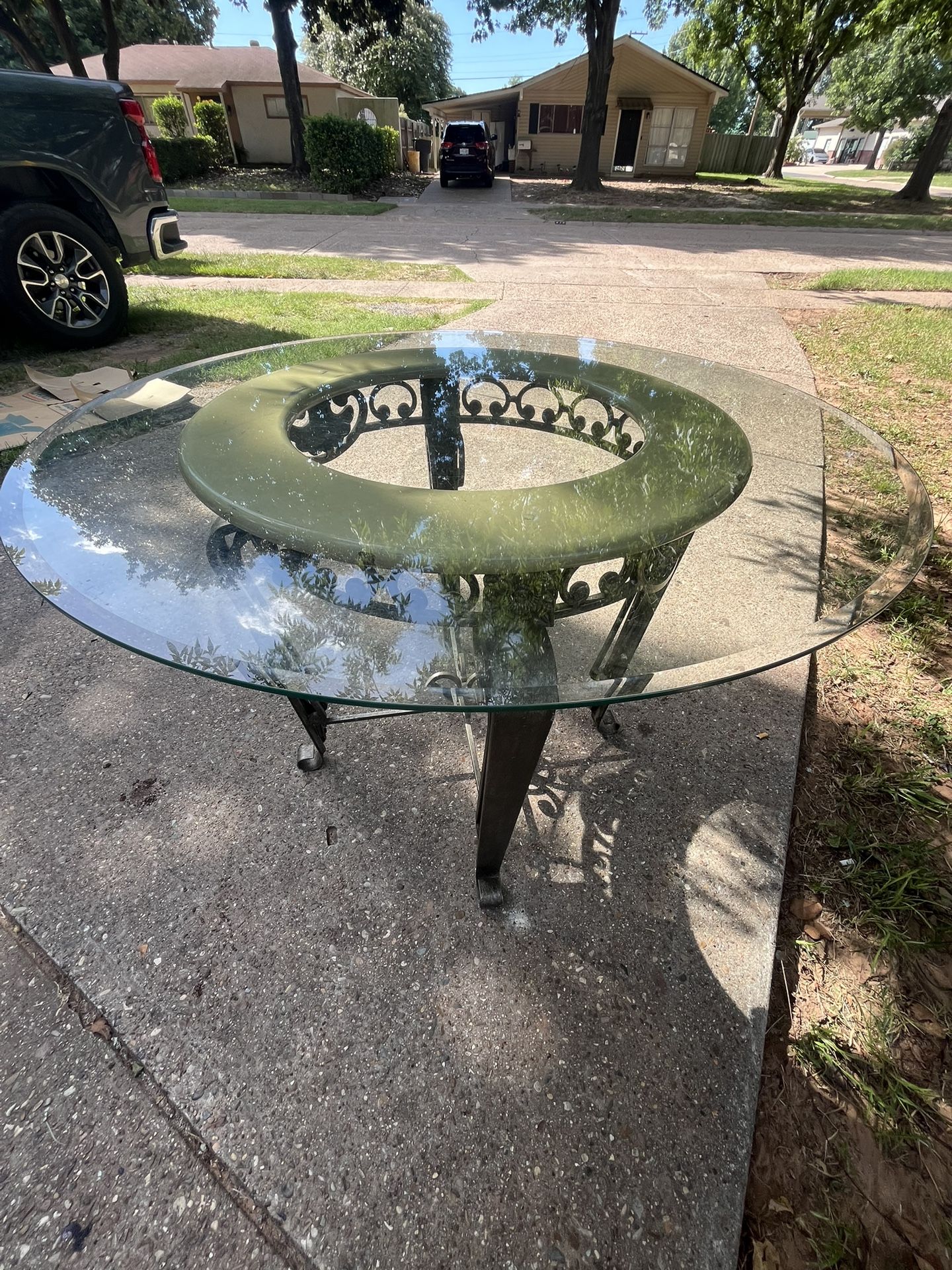 Elegant Round Glass Patio Table with Ornate Iron Base