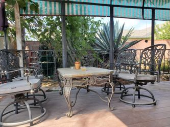 PATIO FURNITURE SET WROUGHT IRON SLATE TILE TOP TABLE WITH 4 SWIVEL CHAIRS.