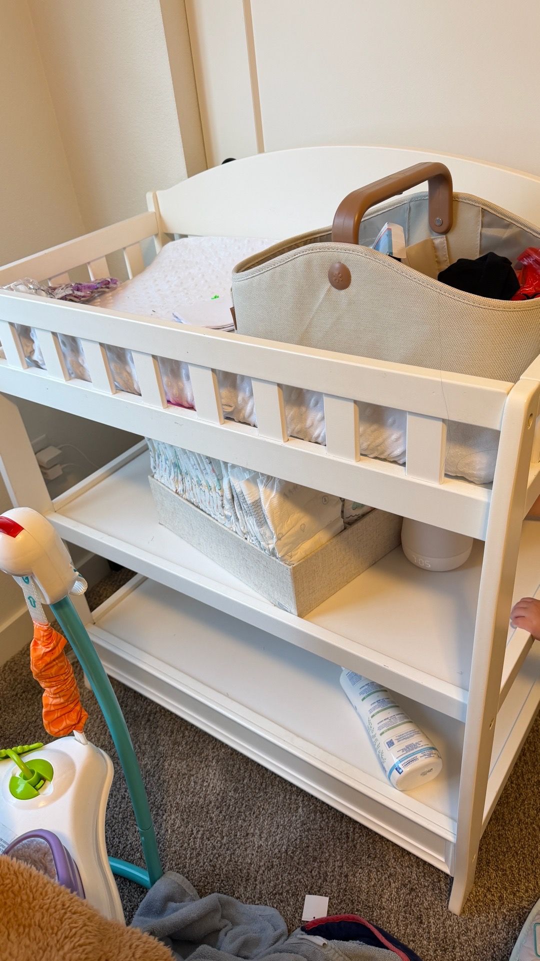 White baby changing table with changing pad and cover