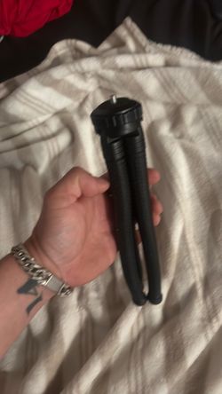 black mini tripod features flexible legs and a ball head