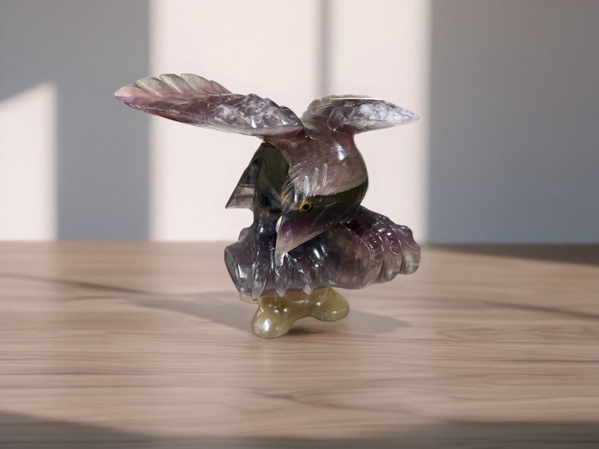 The sculpture is crafted from fluorite, a mineral known for its vibrant colors and often exhibiting a purple hue, as seen in the image. The specific p